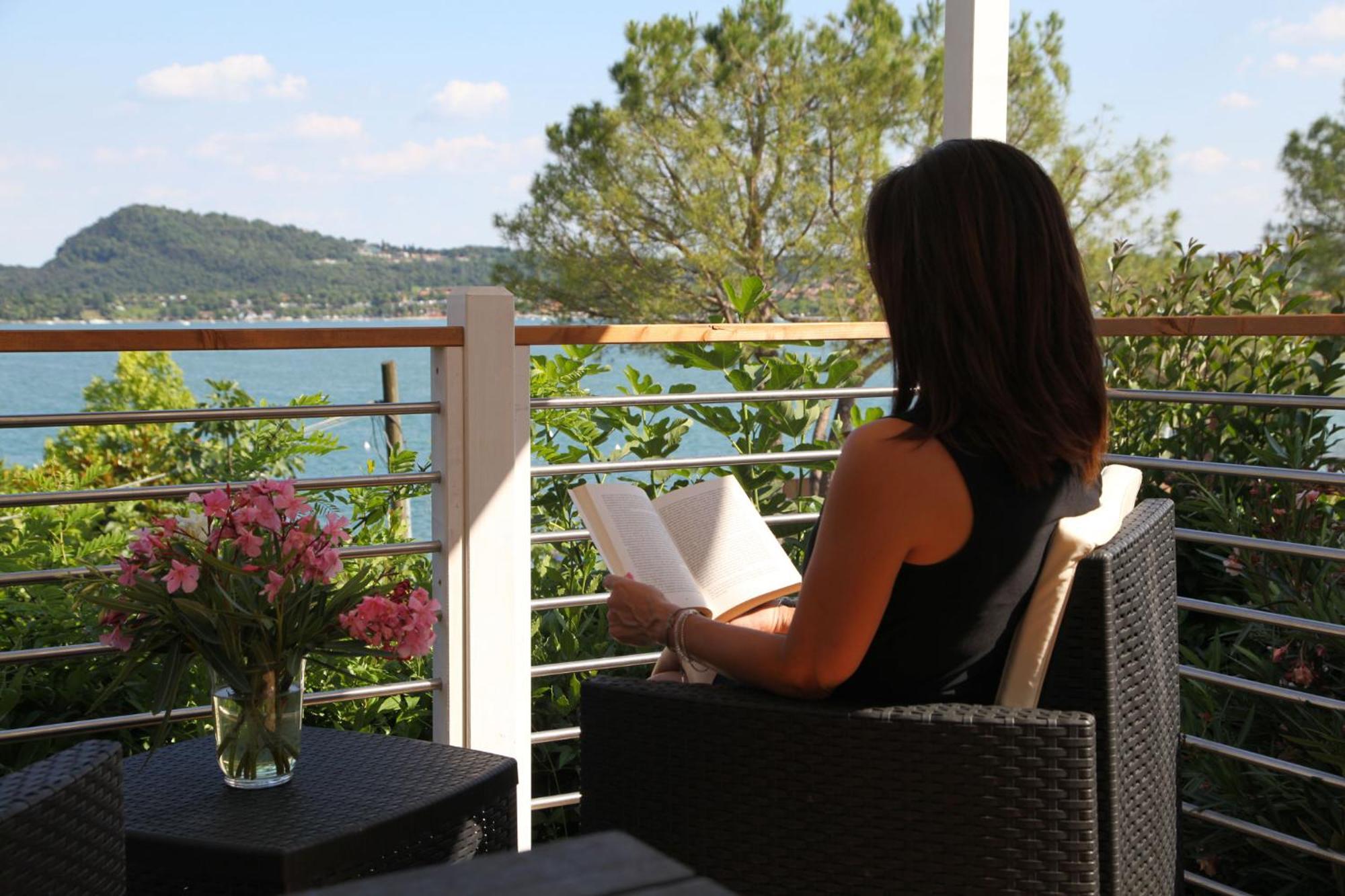 Campeggio Europa Silvella San Felice del Benaco Esterno foto A woman reading on a balcony